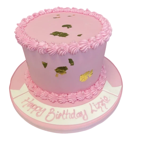 A beautifully decorated cake featuring delicate shell designs and elegant gold leaf accents, perfect for a special celebration.