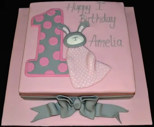 Square bespoke celebration cake featuring a large number 1 and a rag bunny in Solihull, West Midlands.