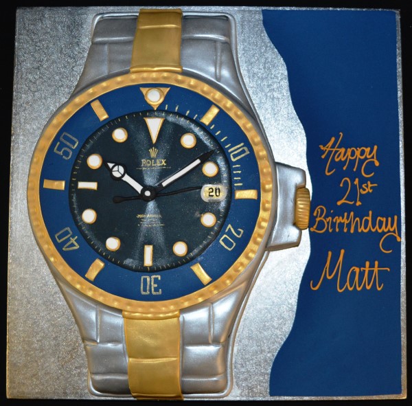Bespoke cake shaped like a Rolex watch with detailed gold and black design, crafted in Solihull, West Midlands.