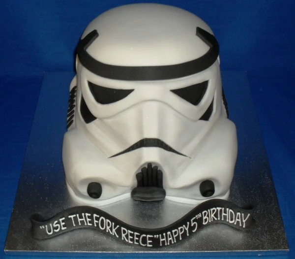 A unique Storm Trooper head-shaped cake perfect for any Star Wars fan, featuring intricate details and a striking design. Perfect for themed parties or celebrations.