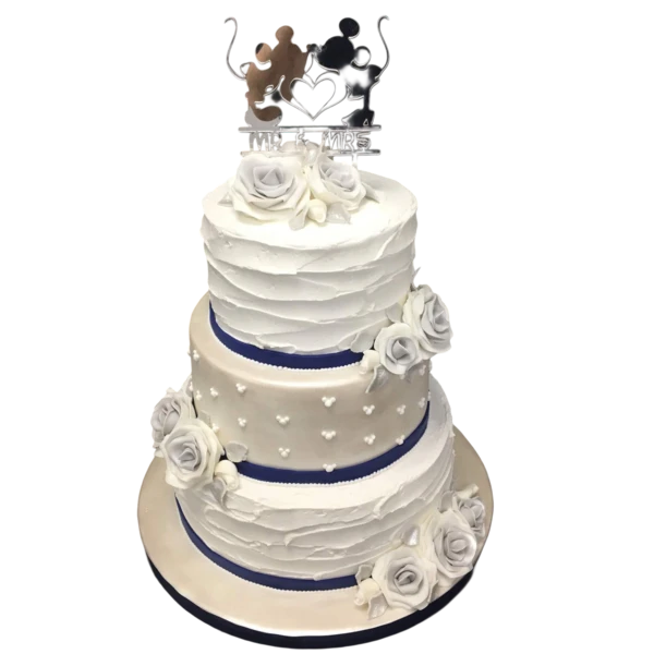 Three-tiered wedding cake with white sugar paste and navy ribbon accents.