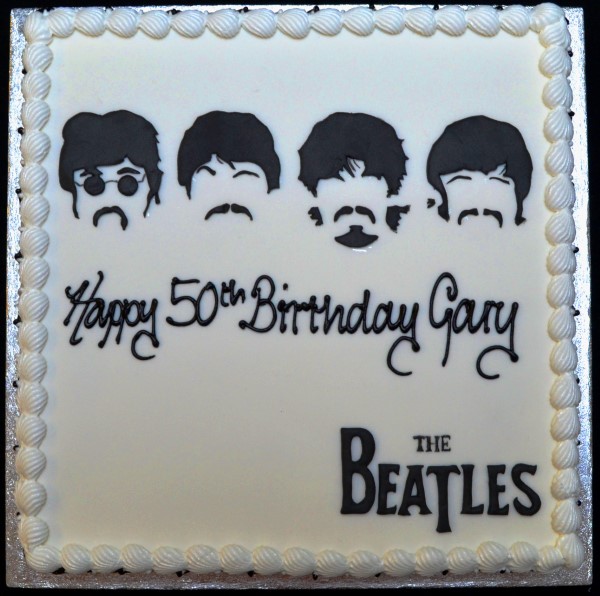 Bespoke Beatles-themed celebration cake with colorful musical notes, records, and Solihull, West Midlands backdrop.