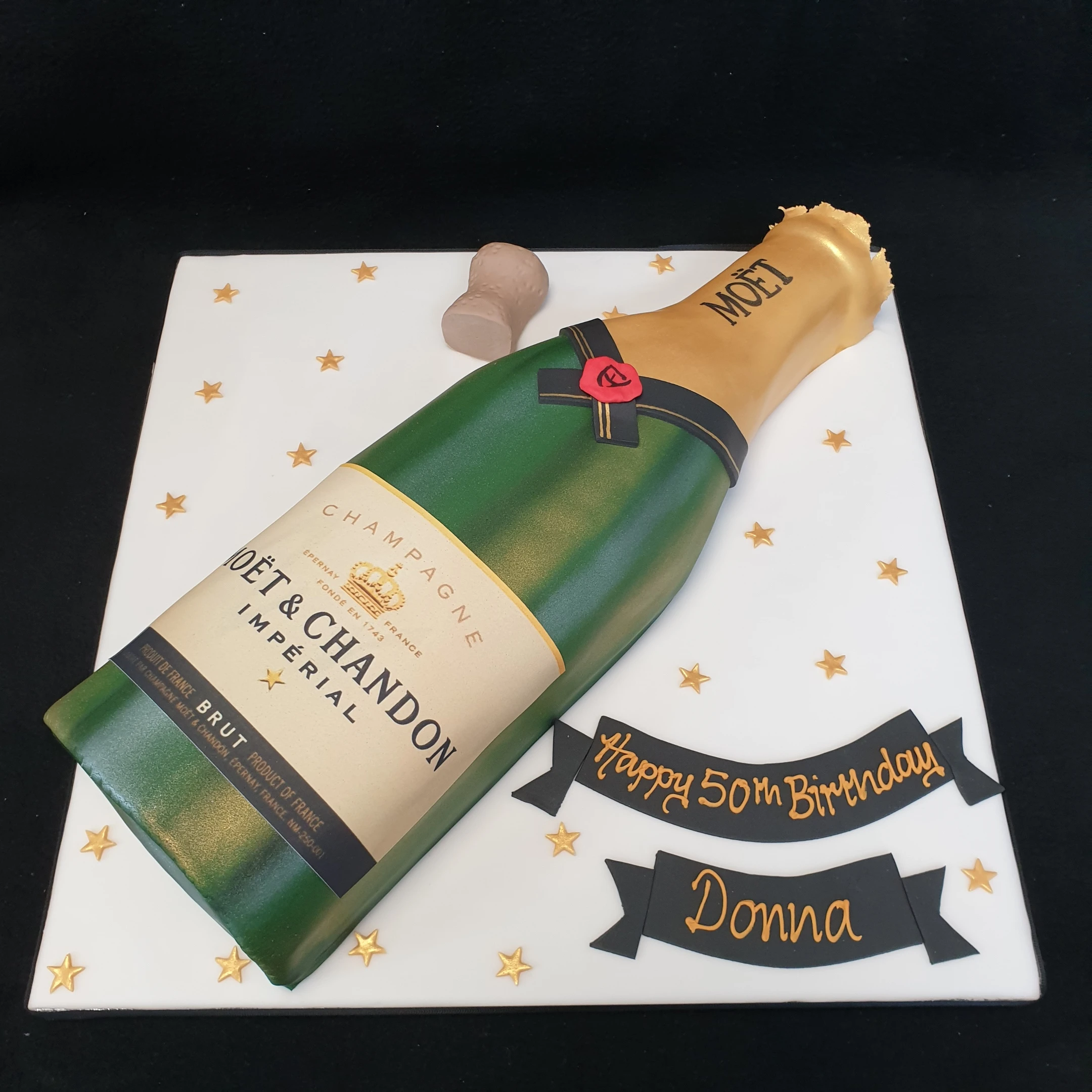 Bespoke cake shaped like a Moet champagne bottle, decorated with detailed labels, in Solihull, West Midlands.