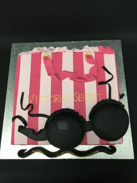 Bespoke cake shaped like Victoria's Secret bag and bra, decorated with pink and black details in Solihull, West Midlands.