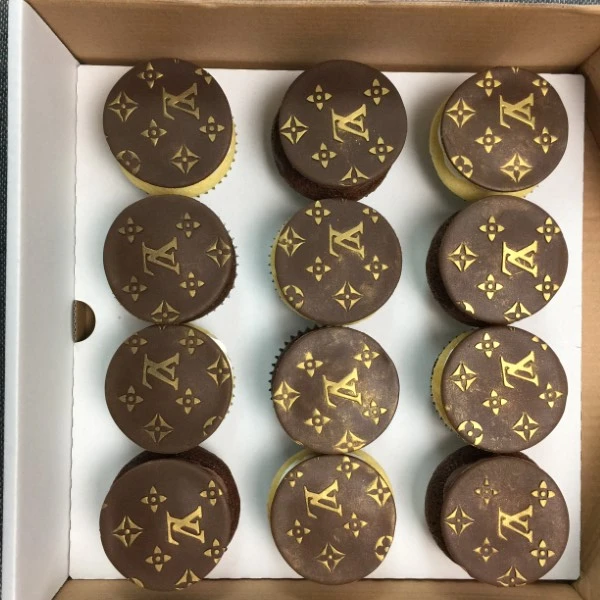 Bespoke LV cupcakes with intricate logo designs, perfect for celebration in Solihull, West Midlands.