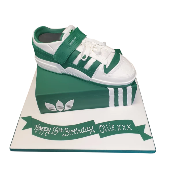 A sleek and stylish Adidas shoe box-shaped cake decorated with green and white trainer details, perfect for sneaker lovers and sports enthusiasts.