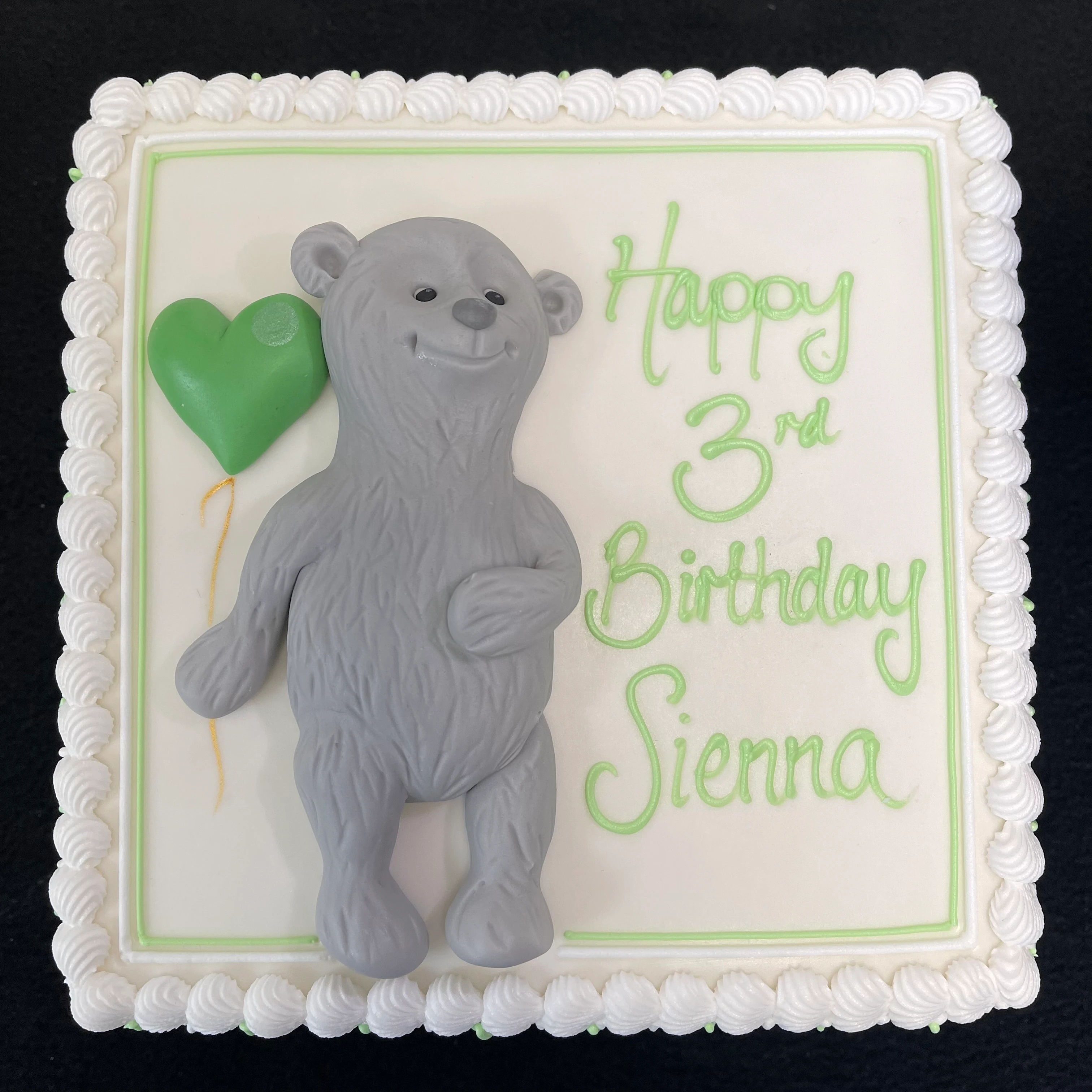 Adorable grey bear cake with a cute balloon for a birthday celebration, perfect for kids' parties or special occasions.