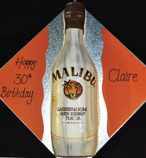 Bespoke Malibu-themed cake with tropical decorations, vibrant colors, and palm leaves in Solihull, West Midlands.