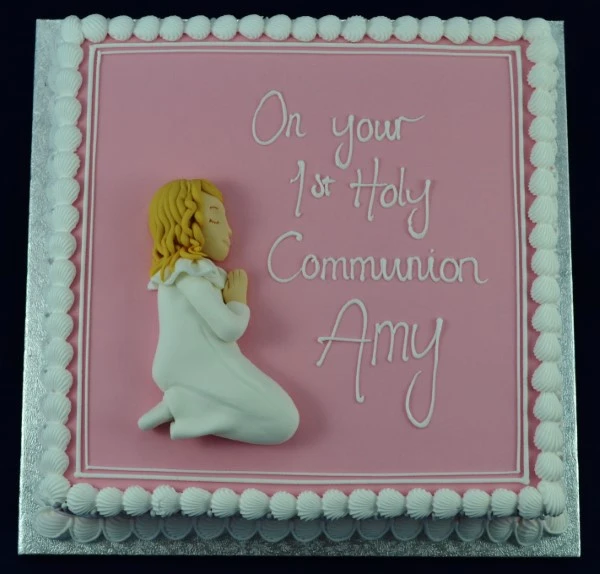 Bespoke Communion cake featuring a delicate girl figurine and white floral decorations in Solihull, West Midlands.