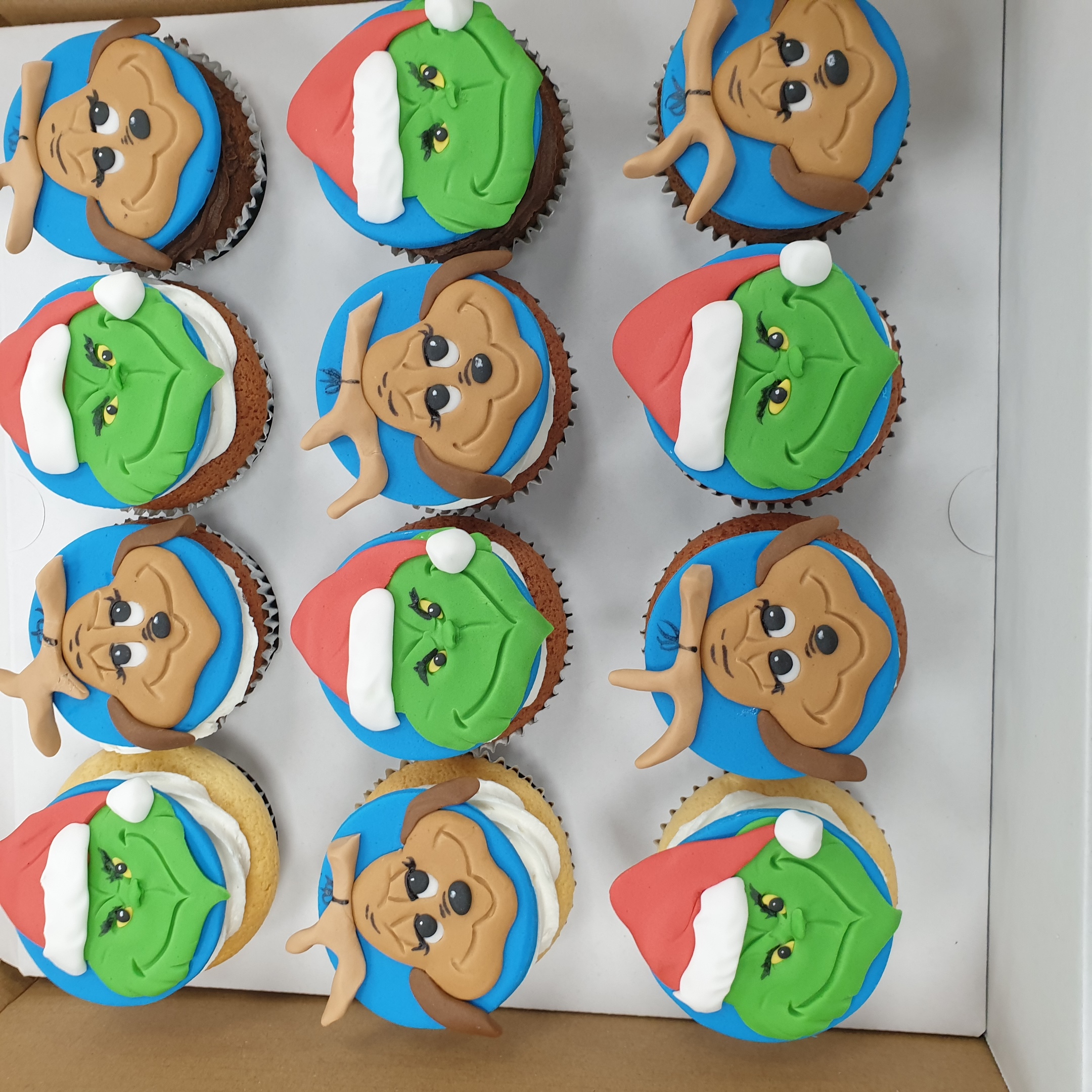 Bespoke Grinch and Max cupcakes with detailed fondant figures, perfect for celebration in Solihull, West Midlands.