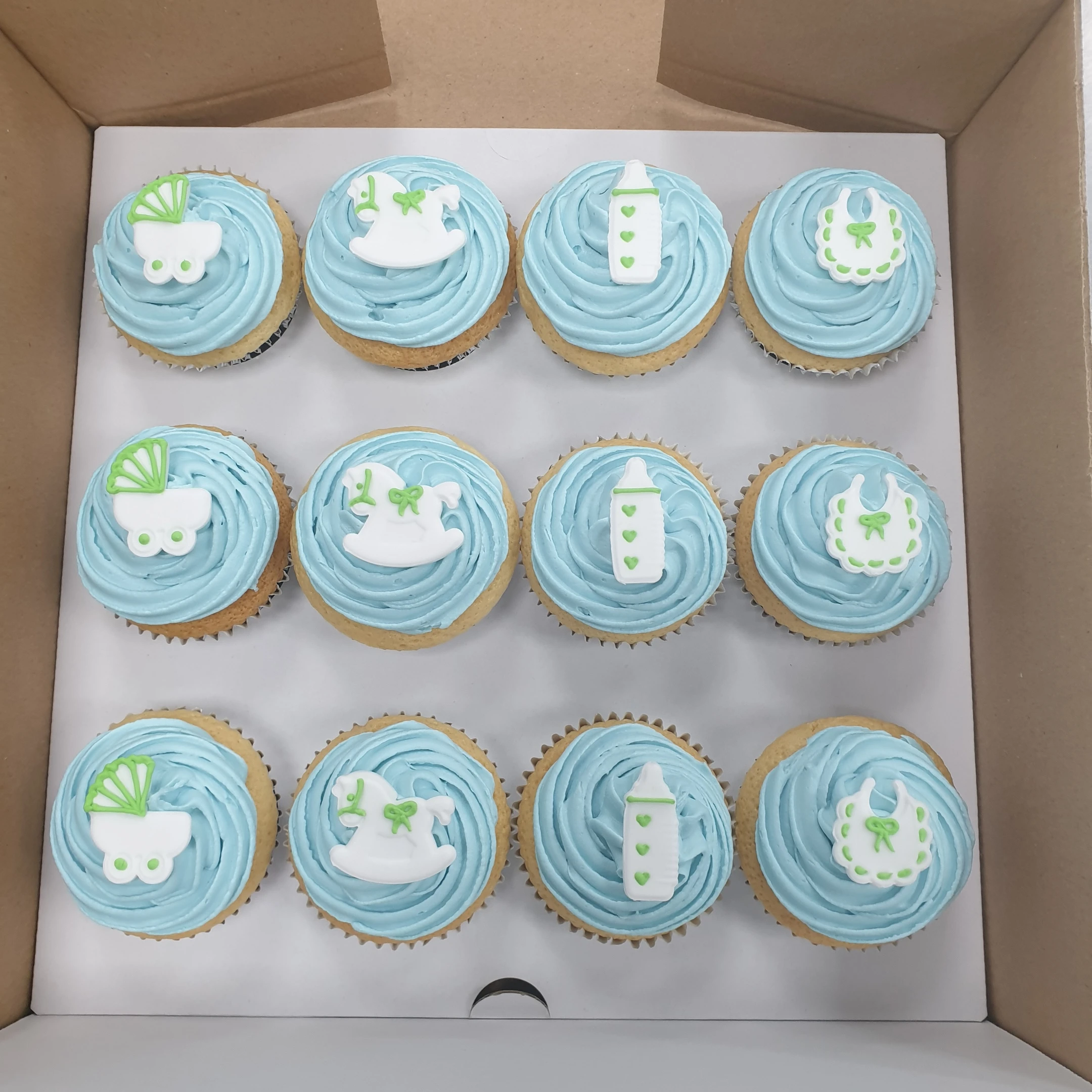 Bespoke baby shower cupcakes decorated with pastel fondant and baby-themed toppers in Solihull, West Midlands.