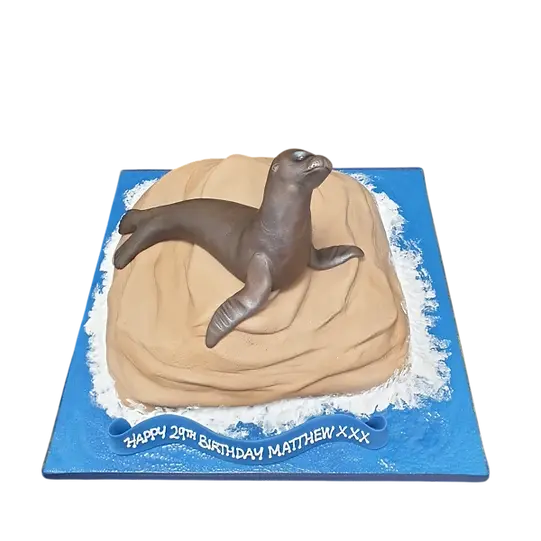 Bespoke cake featuring a detailed seal resting on a textured rock, crafted for celebration in Solihull, West Midlands.