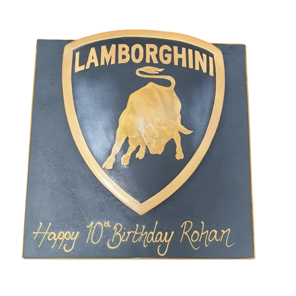 Bespoke cake shaped like a Lamborghini badge with black, gold, and green detailing, made in Solihull, West Midlands.