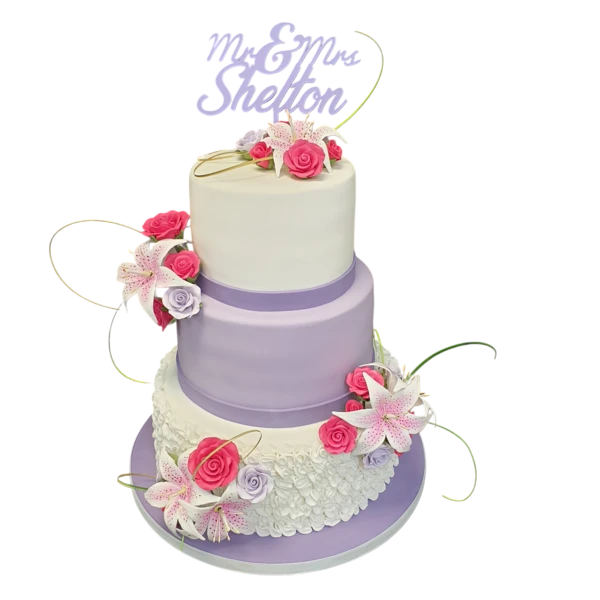 Three-tier wedding cake with sugar paste flowers and lavender accents.