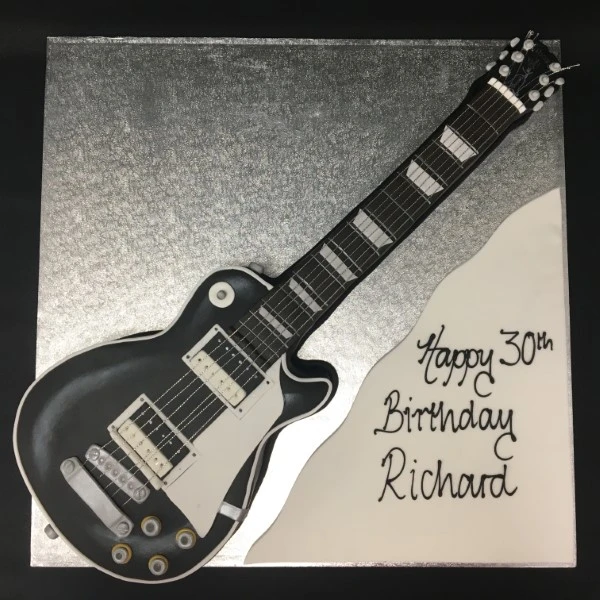 A creatively designed electric guitar themed cake with intricate details and vibrant colors perfect for music lovers and guitar enthusiasts.