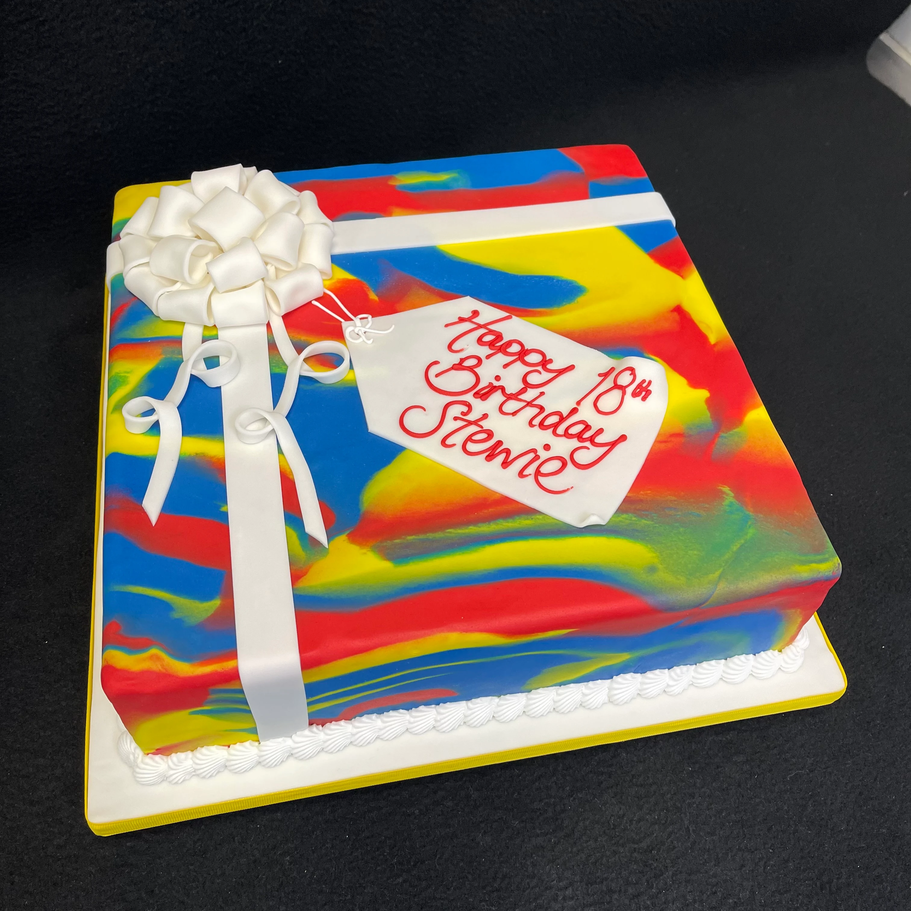 Bespoke Primary Parcel cake with colorful blocks and letters, perfect for celebration in Solihull, West Midlands.