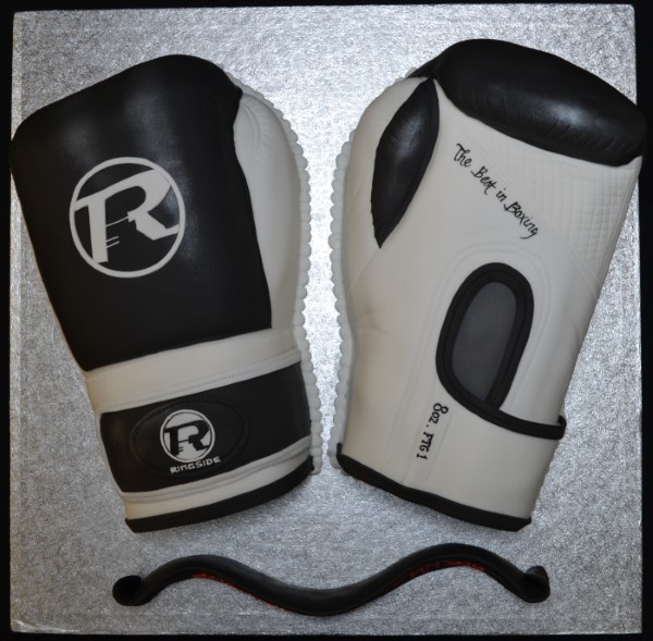 Bespoke celebration cake shaped like red boxing gloves with detailed stitching, crafted in Solihull, West Midlands.
