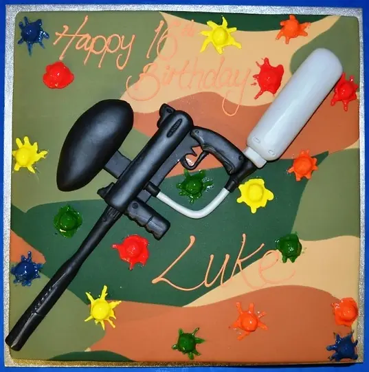 Bespoke cake shaped like a paintball gun on a square base, crafted for celebration in Solihull, West Midlands.