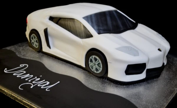 Luxurious custom-designed sports car cake shaped like a Lamborghini Aventador, perfect for car enthusiasts and special celebrations.