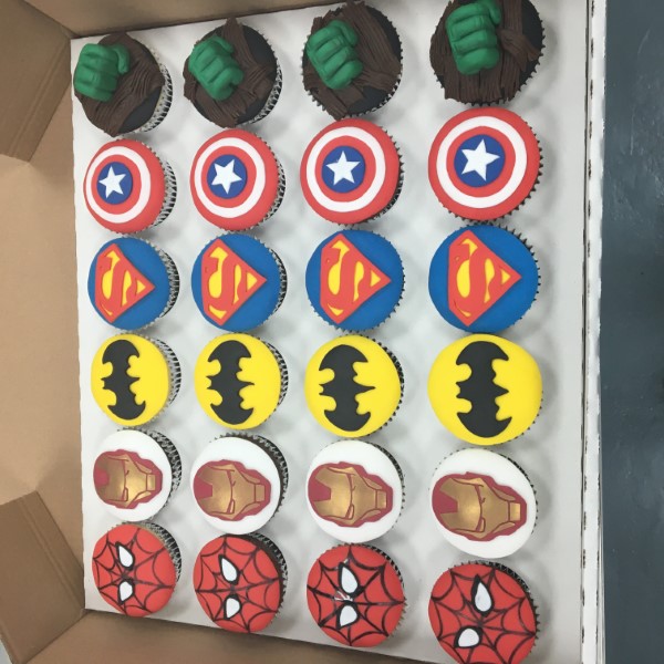 Bespoke superhero-themed cake with vibrant edible figures and cityscape details in Solihull, West Midlands.