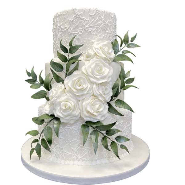 Three-tier white wedding cake with sugar paste roses and green foliage decoration.