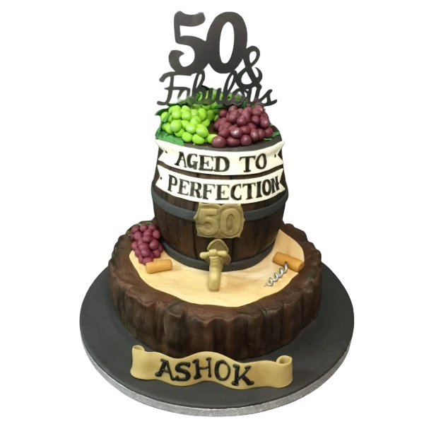 Bespoke celebration cake in Solihull, West Midlands featuring a wine barrel and grapes on a tree stump with laser-cut topper.