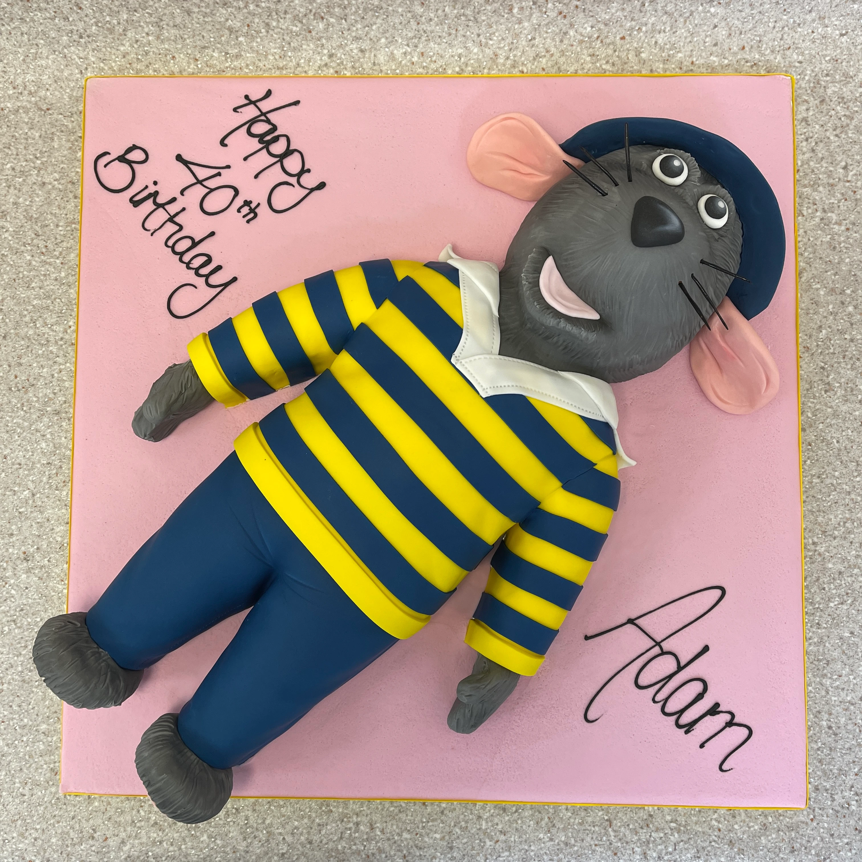 A whimsical and colourful cartoon character cake featuring Roland Rat, perfect for themed parties and celebrations.