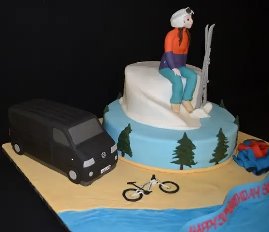 Bespoke celebration cake in Solihull, West Midlands featuring a skier and a van detailed in fondant.