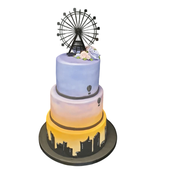 Three-tier wedding cake with cityscape design, pastel hues, and sugar flowers.
