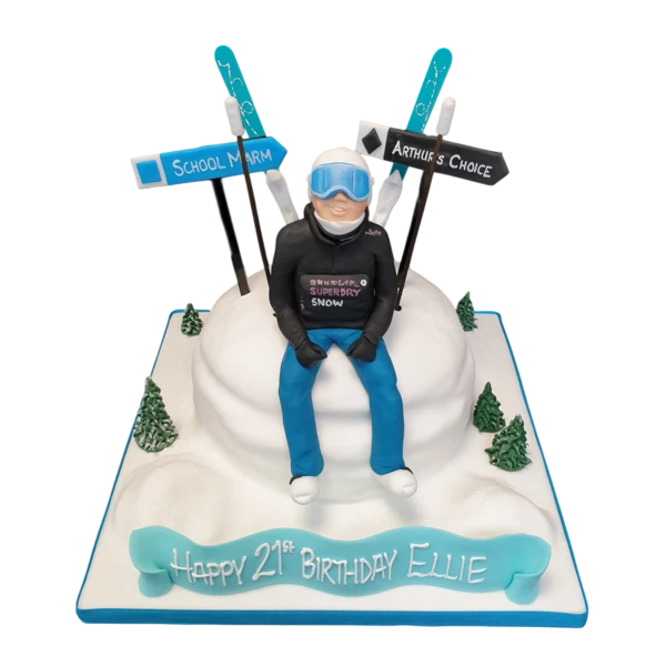 A beautiful white winter-themed cake featuring a skier figurine on a snowy mound, perfect for a ski enthusiast's celebration.