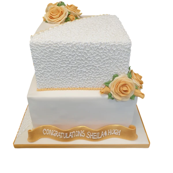 Two-tier wedding cake with peach sugar roses and textured white design.