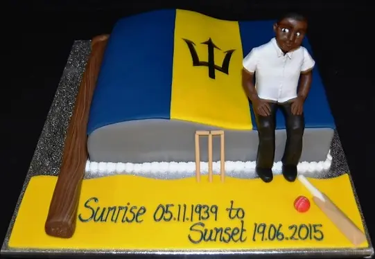 Bespoke cake featuring the Barbados flag and a figure, crafted for celebration in Solihull, West Midlands.