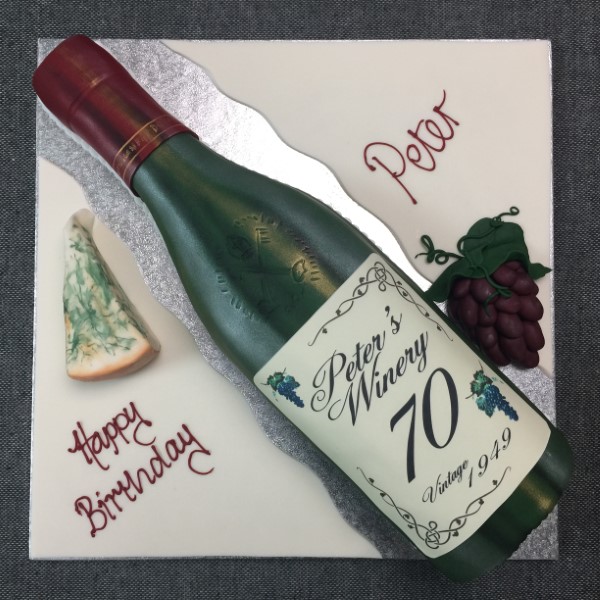 Bespoke cake in Solihull, West Midlands shaped like a wine bottle and cheese for a celebration.