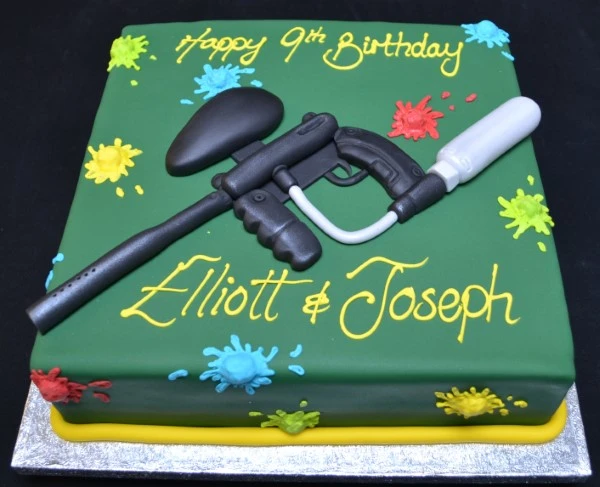 Bespoke paintball gun shaped cake with detailed colors and textures, perfect for celebration in Solihull, West Midlands.