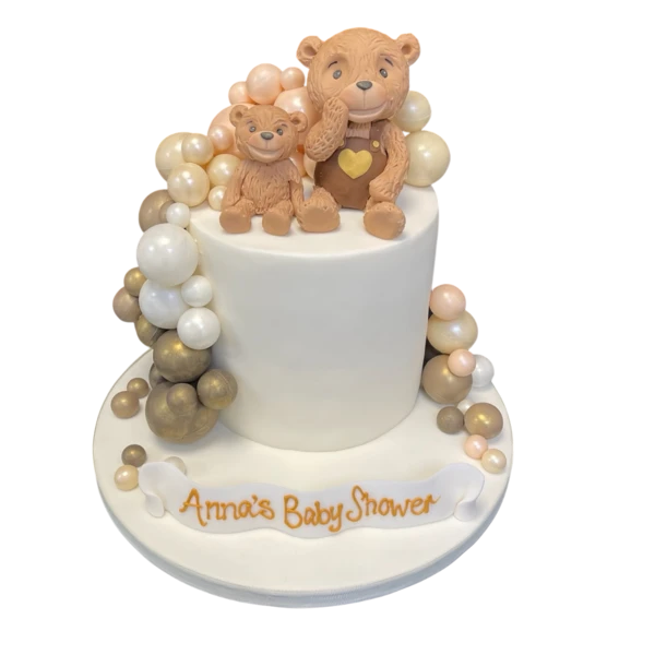 A cute and whimsical cake with smiling bear figures and colorful balls as decoration, perfect for a fun and festive celebration.