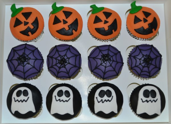 Bespoke Halloween cupcakes with orange and black frosting, spiderweb designs, and candy decorations in Solihull, West Midlands.
