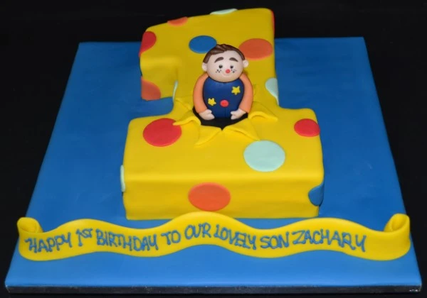 A beautifully decorated cake featuring a figure 1 and Mr Tumble character, perfect for a themed celebration. Great for kids parties.