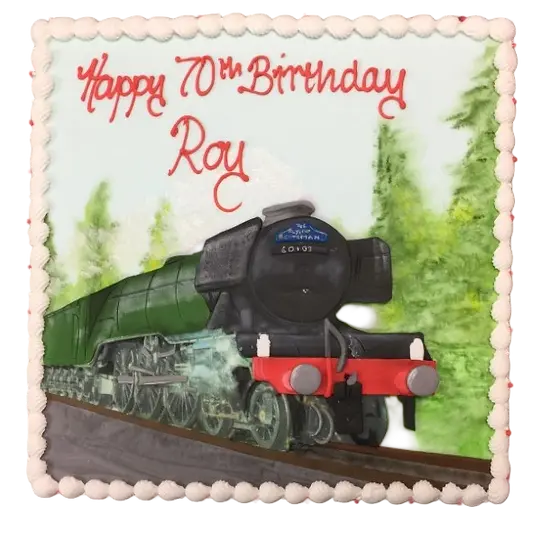 Bespoke train-themed cake with colorful fondant details, set on a green base in Solihull, West Midlands.