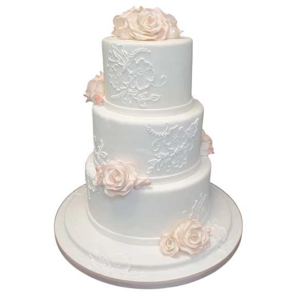 Three-tier white wedding cake with sugar paste floral designs and blush roses.