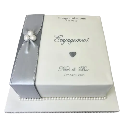 Bespoke engagement cake with white fondant, delicate floral accents, and gold detailing in Solihull, West Midlands.