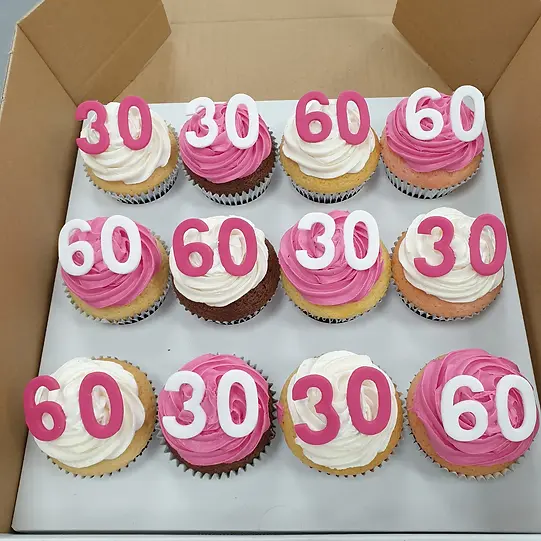 Bespoke cupcakes arranged in a tiered display with pastel frosting, decorated for a celebration in Solihull, West Midlands.