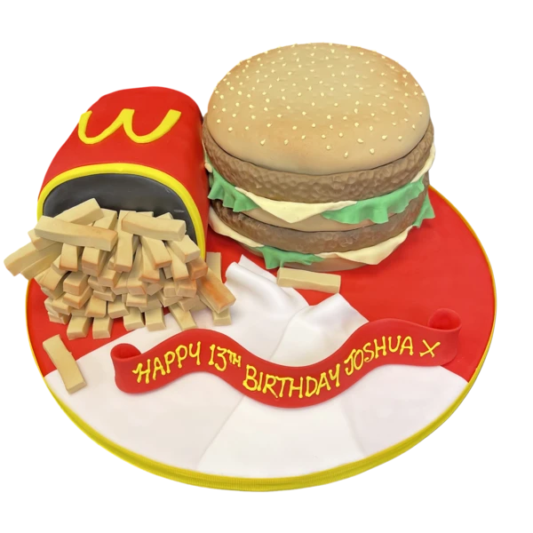 Bespoke celebration cake in Solihull, West Midlands shaped like a McDonald's burger and fries with detailed toppings.