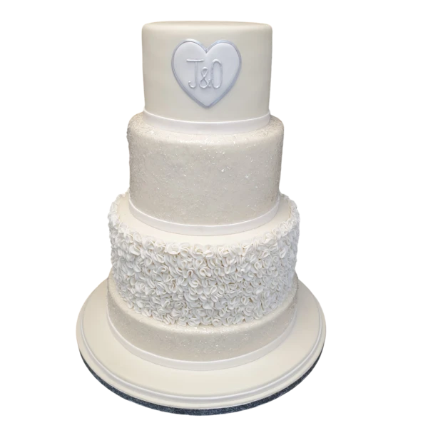 Four-tier white wedding cake with sugar paste flowers and a personalised heart.