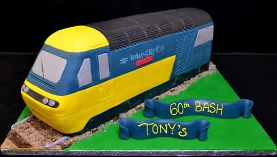 Bespoke diesel locomotive cake with detailed wheels and smokestack, crafted for celebration in Solihull, West Midlands.