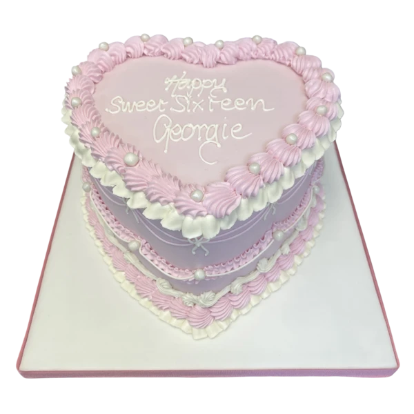 A beautifully designed heart-shaped cake with intricate piped decorations, perfect for celebrating special occasions and events.