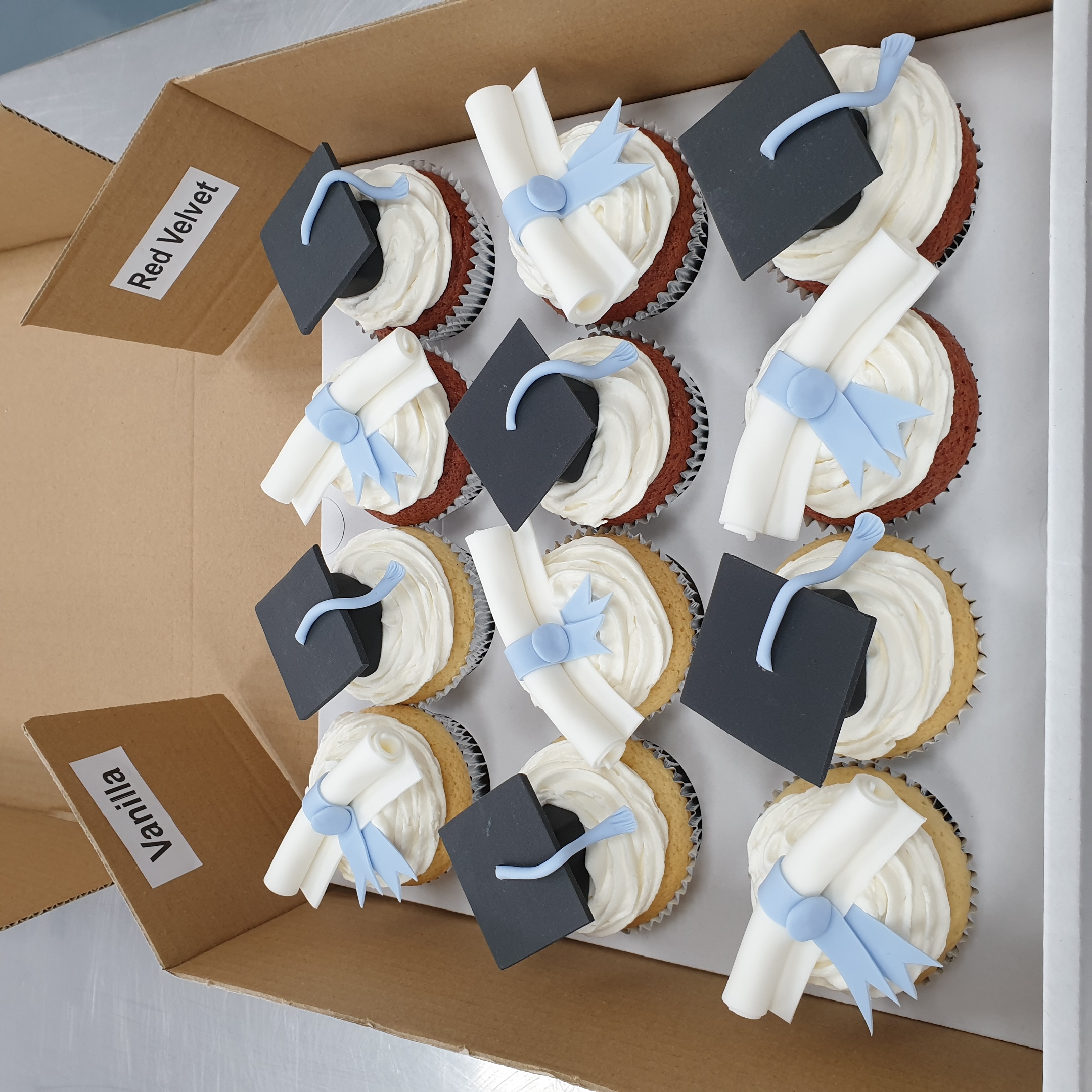 Bespoke graduation cupcakes with mortarboard toppers and gold accents, celebrating success in Solihull, West Midlands.