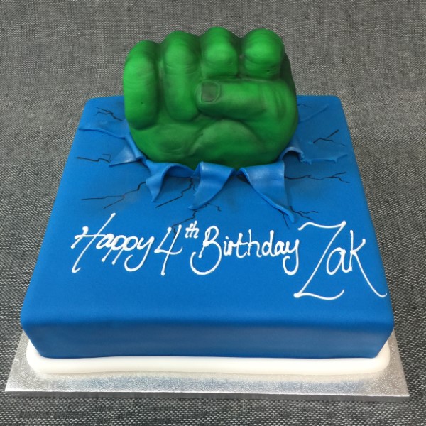 A unique and vibrant Hulk-themed cake shaped like a powerful fist on a square base, perfect for superhero-themed parties and celebrations.