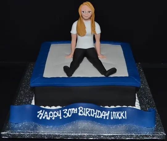Bespoke trampoline-themed cake with vibrant colors and detailed netting, crafted in Solihull, West Midlands.