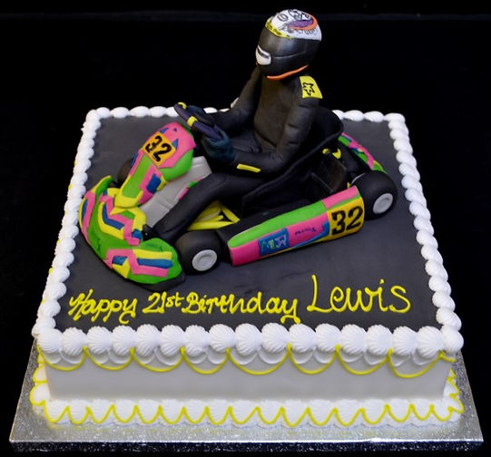 Bespoke go-kart themed cake with detailed edible wheels and racing decals, crafted in Solihull, West Midlands.