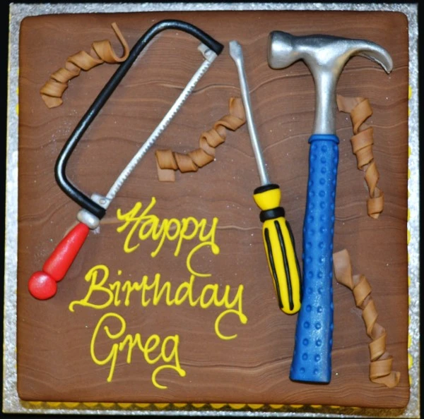 Bespoke celebration cake shaped like various colorful tools, crafted in Solihull, West Midlands.